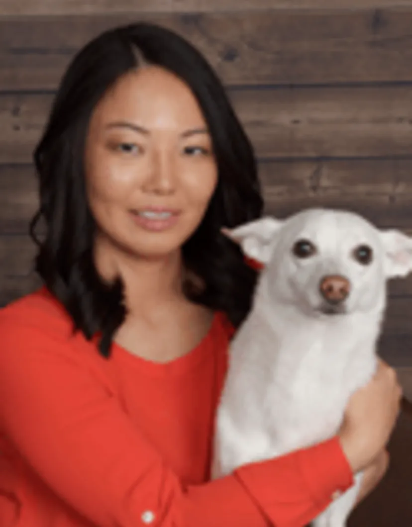 Sae Miyoshi holding a small white dog.